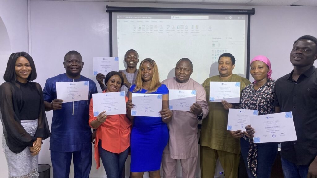 Group of diverse Nigerian students proudly holding their WDC (Wild Fusion Digital Centre) training certificates in a classroom.